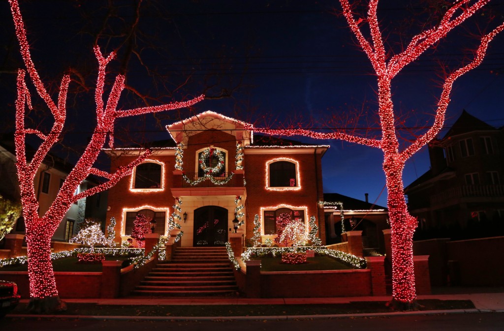 Glowing Christmas Lights And Trees Over House
